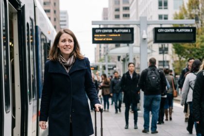 Femme attendant sur une plateforme de train avec valise